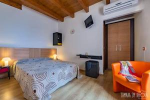夏卡Locanda Al Moro Hotel的一间卧室配有一张床和一个橙色的沙发