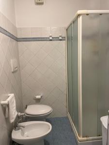 努马纳Casa Bianca Stella的一间带卫生间和玻璃淋浴间的浴室