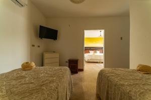 索里托斯Hotel Boutique Noelani的带两张床和电视的房间以及一间卧室