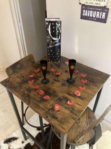 埃尔布莱La nuit glamour的一张桌子,上面放着两杯酒和粉红色的玫瑰花