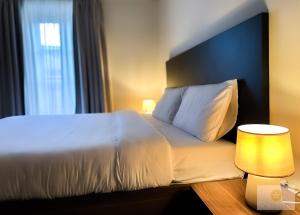 圣朱利安斯Ta' Tereża Seafront Apartments的一间卧室配有一张白色的床和蓝色床头板