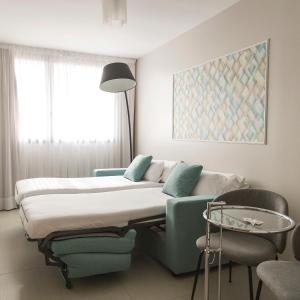 萨拉戈萨萨拉戈萨瑞市酒店及水疗中心的配有一张床和一把椅子的酒店客房