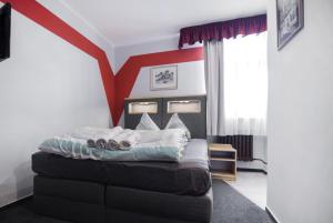 尼萨河畔亚布洛内茨阿卡亚膳食公寓旅馆的一间卧室配有一张红色条纹的床