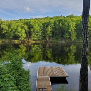 Lac-aux-SablesChalet de luxe Équinoxe - bord de l'eau avec Spa的中间有一个码头的宁静湖泊