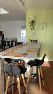 塞尔吉Bel appartement tout confort aux Portes de Paris的厨房配有一张桌子和四把黑吧台凳