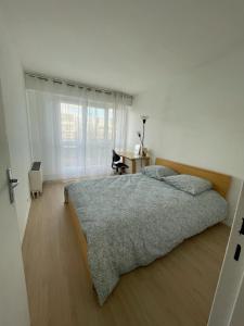 塞尔吉Bel appartement tout confort aux Portes de Paris的一间卧室设有一张大床和一个窗户。
