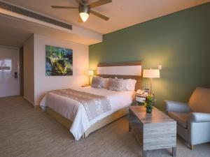 卡塔赫纳美洲海塔酒店的一间卧室配有一张床、一张沙发和一把椅子