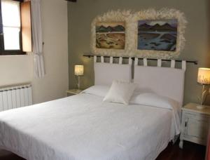 戈特赫斯阿特亚加Casa Rural Ozollo的卧室内的一张白色床,配有两盏灯