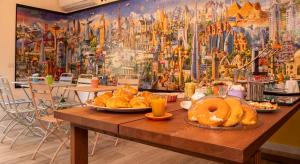 加埃塔Wanderlust B&B的一张桌子,上面有面包和甜甜圈,上面有壁画