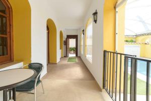 格拉纳达Casa Rural "compartida" La Loma的走廊设有黄色的墙壁和桌椅