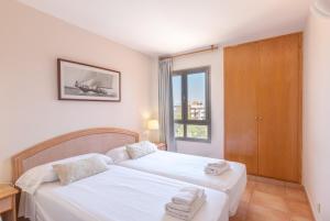 科洛尼亚圣霍尔迪Holiday beach homes Romaní II的一间卧室设有两张床和窗户。