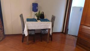 安加罗阿Cabañas Hua'ai Village的桌子和椅子,上面有桌子和花瓶