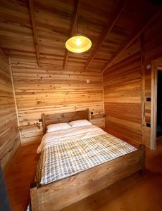 伊兹密尔Flow Urla的木制客房内的一间卧室,配有一张床