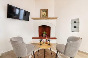 塞奥洛戈斯M&K Traditional House的一间带三把椅子的桌子和一台电视机的房间