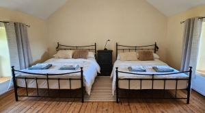 Plumb BridgeThe Home House的卧室设有两张单人床和两扇窗户。