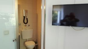 费尔贝特Hotel Bergische Schweiz的一间带卫生间的浴室和一台平面电视