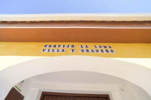 格拉纳达Casa Rural "compartida" La Loma Granero的门廊上标有标志的建筑物入口