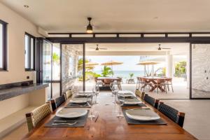 艾库玛尔CASA MILAH TULUM 8BDR BEACH FRONT PRIVATE-CHEF VILLA WEDDINGS-RETREATS-FAMILY GATHERINGS的一间带长桌的海景用餐室