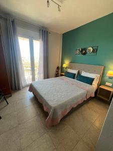 奥马斯帕纳吉亚斯Sofia & Lakis House的一间卧室配有一张带蓝色墙壁的大床