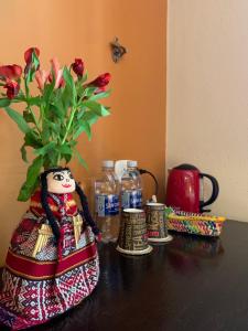 马丘比丘全景住宿加早餐酒店的花瓶,桌子上装有鲜花,瓶子