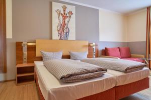 金茨堡罗马酒店的卧室配有两张床,墙上设有一个花瓶