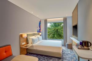 班加罗尔Holiday Inn Express Bengaluru Bommasandra, an IHG Hotel的酒店客房设有床和窗户。