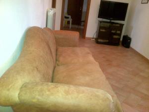 斯波莱托Nonna Alda的客厅里设有一张棕色沙发,配有电视