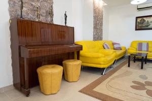 卡斯特利翁-德拉普拉纳Casa Moderna cerca de la PLAYA的客厅配有钢琴和黄色沙发