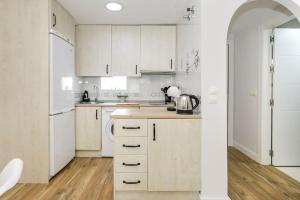莫纳奇尔Apartamento Carmela的白色的厨房配有白色橱柜和冰箱。