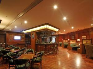 贾朗达尔贾朗达尔丽筠酒店的一间带桌椅的餐厅和一间酒吧