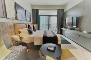 Al Faq‘Modern Apartment close to Burj Khalifa的一间卧室配有一张大床和一张沙发