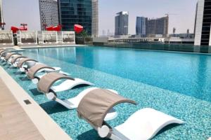 Al Faq‘Modern Apartment close to Burj Khalifa的大楼内一个带躺椅的游泳池