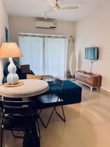 GoaLuxury apartment Blue lagoon的客厅配有桌子和沙发