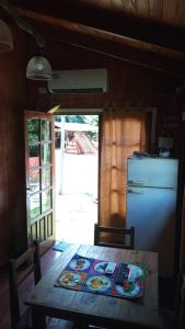 Puerto BossettiCabañas Aliwen的厨房配有桌子和冰箱