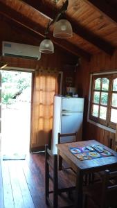 Puerto BossettiCabañas Aliwen的厨房配有木桌和冰箱。