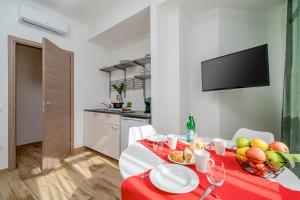 卡利亚里Residenze Asproni Serviced Apartments的用餐室配有带一碗水果的桌子