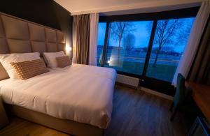 霍夫多普MA Airport Hotel的一间卧室设有一张大床和一个大窗户