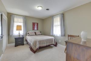 蒙哥马利Garden District Home Near Downtown Montgomery的一间卧室配有一张床、一个梳妆台和两个窗户。
