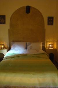 梅克内斯里亚德薄荷逸柚酒店的一间卧室配有一张大床和大床头板