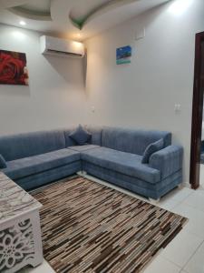 Taymāʼجوهرة الاماكن的客厅配有蓝色的沙发和地毯。