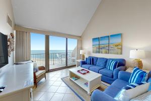 贝瑟尼滩Sea Colony Chesapeake House IV的一间带蓝色沙发的客厅和一个阳台