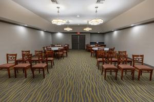 欧文Red Roof Inn & Suites Irving - DFW Airport South的用餐室配有桌椅和灯光