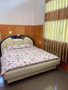 隆海LAN168的一间卧室配有一张带花卉床罩的床