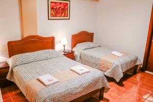 CarhuazLas Torrecitas的两张位于酒店客房的床,配有毛巾