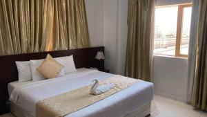 索哈尔SADARA HOTELS APARTMENTS的一间卧室配有一张带天鹅的床