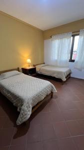 塔里哈Apartamento Maracuyá en Tarija的一间卧室设有两张床和窗户。