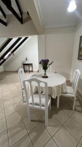 塔里哈Apartamento Maracuyá en Tarija的白色的桌子,白色的椅子和花瓶