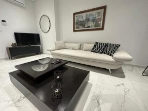 拉马萨Luxury appartement的客厅配有白色的沙发和桌子