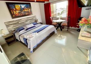 蓬塔内格拉Hostal Ocean Pacifico的酒店客房设有一张床铺、一张桌子和一张桌子。