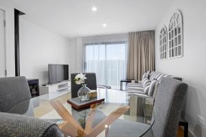 Albert TownWanaka Riverside serviced apartments by BCR Stays的客厅配有玻璃桌和椅子